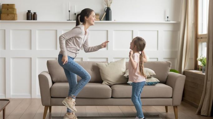 Two siblings play together in a living room