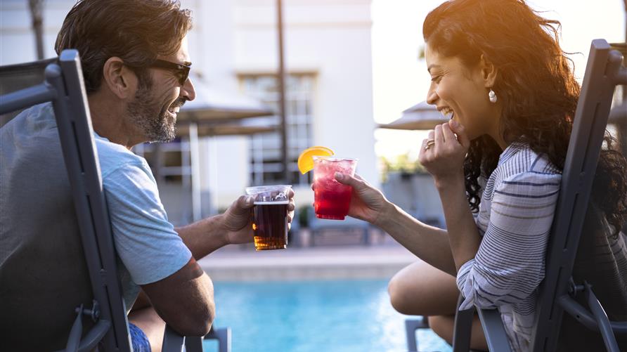 A happy couple toasting poolside at a Hilton Grand Vacations Club in Orlando, Florida. 