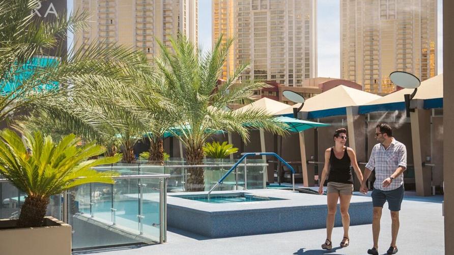 A couple walking together poolside at Elara a Hilton Grand Vacations Club in Las Vegas, Nevada. 