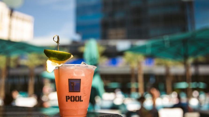 A frozen cocktail pictured on a Hilton Grand Vacations bar with the pool in the background. 