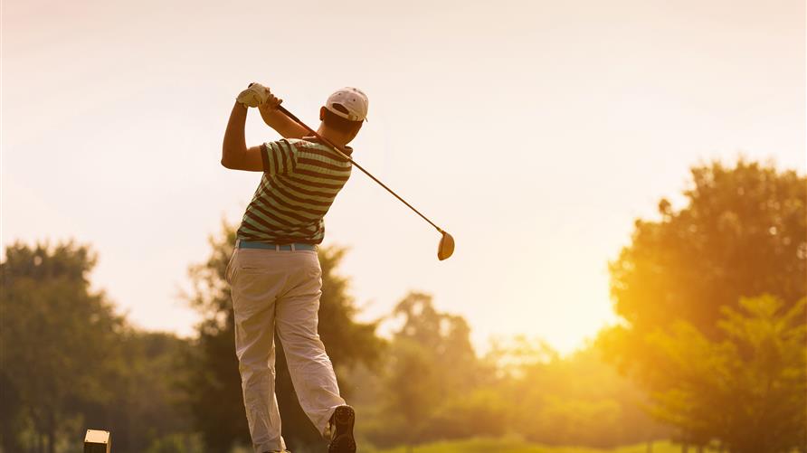 Man facing the sunset swinging a golf club on a Myrtle Beach golf course in South Carolina. 