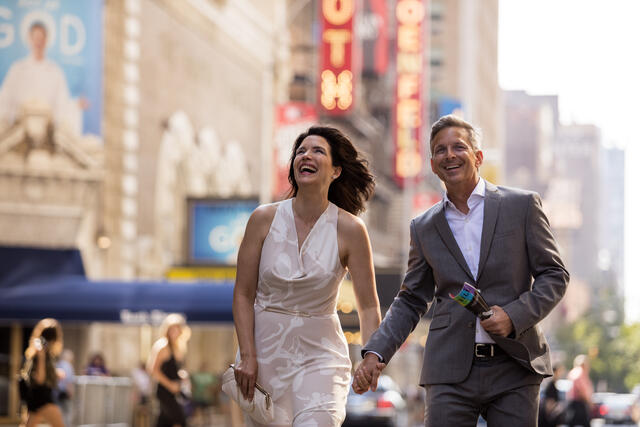Happy couple walking hand in hand down New York City street. 