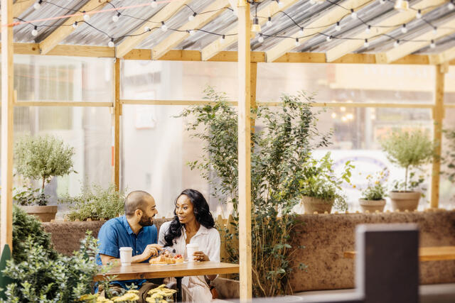 Couple talking over lunch at midtown Manhattan outdoor cafe, New York, New York. 