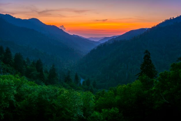 The Great Smoky Mountains with the glowing rising sun in the distance, Pigeon Forge, Tennessee. 