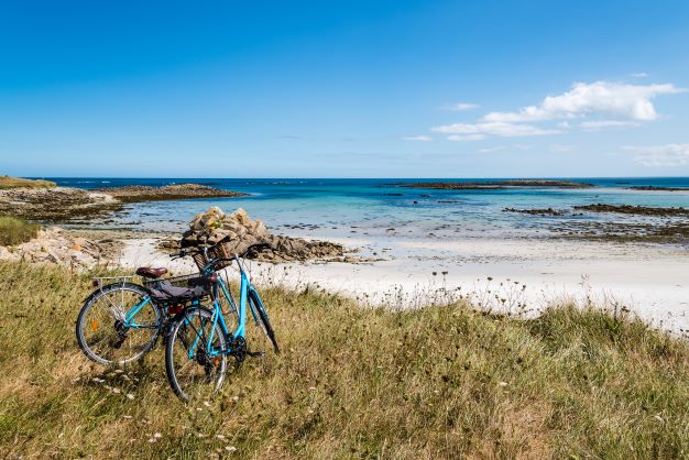 Georgeous seaside vista with two bicyles parked off to the side. 