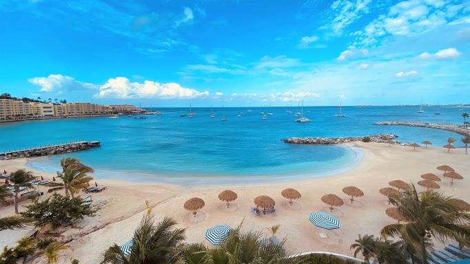 Palm trees and umbrellas on the beach of Simpson Bay in St. Maarten