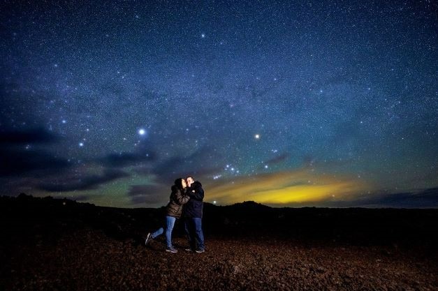Hilton Grand Vacations Owners posing, the Milky Way shining overhead, Mauna Loa, Hawaii. 