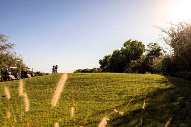 Two golfers walk from golf carts to a course near Mystic Dunes, a Hilton Vacation Club, near Orlando, Florida