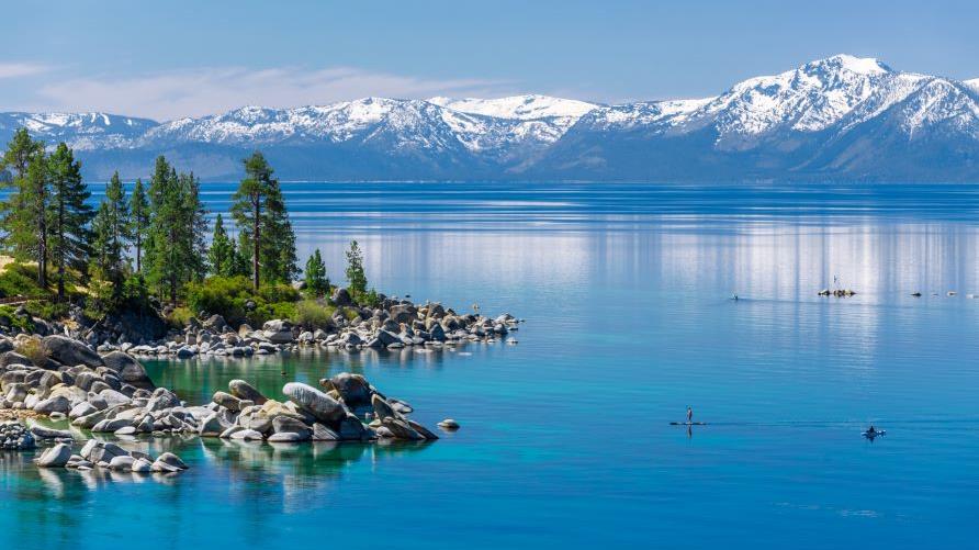 Beautiful aerial image, mountain lake, snow capped mountains in distance, Lake Tahoe, California. 