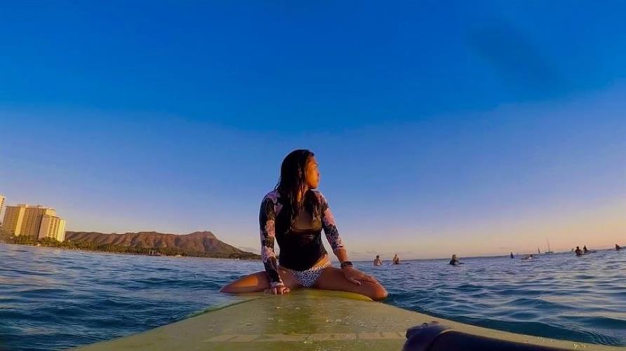 A Hilton Grand Vacations Member on a surfboard in Oahu, Hawaii
