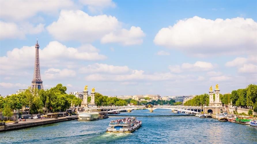 The Eiffel Tower in Paris overlooking the Seine River and a boat cruise