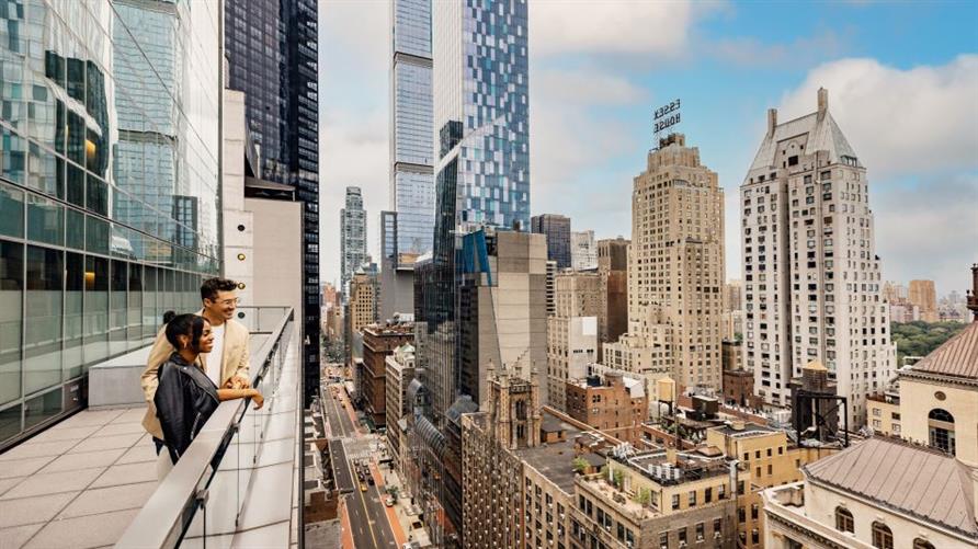 Two people enjoying the view from the terrace of West 57th Street, a Hilton Club, one of Hilton Grand Vacations' New York timeshares