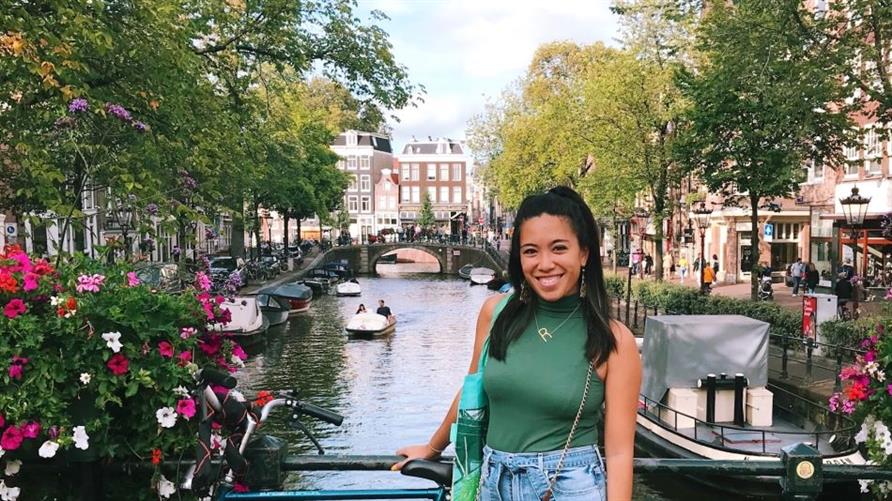 A Hilton Grand Vacations Member posing at a canal in Amsterdam, Netherlands