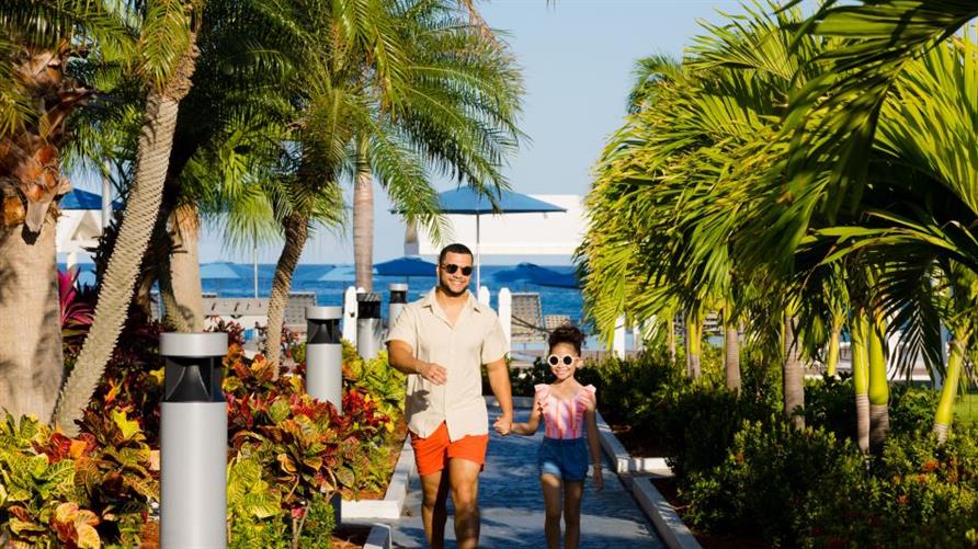A father and daughter head to the beach at Sint Maarten