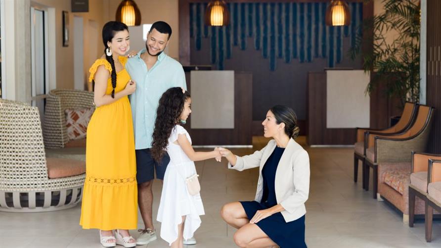A Hilton Grand Vacations Team Member greets a family at a property