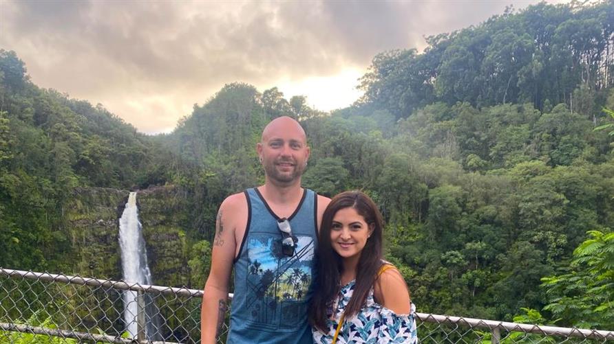 A Hilton Grand Vacations Member and her husband posing by the lush landscape of Big Island, Hawaii