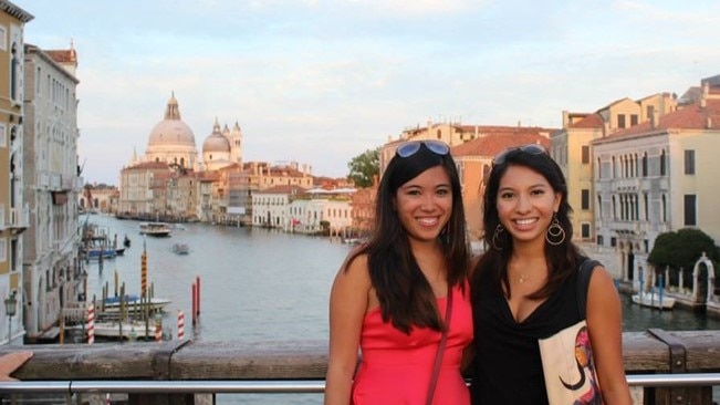 A Hilton Grand Vacations Member and her friend posing by a canal in Venice, Italy