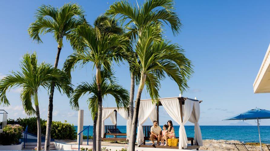 Tropical scene, couple enjoying seaside cabanas, Flamingo Beach, a Hilton Vacation Club, Sint Maarten.