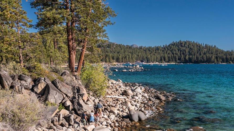 A family walks on the beach at South Lake Tahoe, California