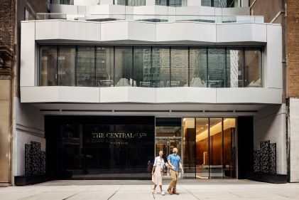 Couple walking in front of Hilton Grand Vacations New York City timeshare resort, New York, New York. 