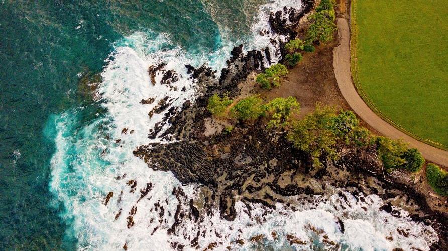 Overhead image, stunning Maui coastline, waves crashing ashore, lava rocks, lush greenery, Road To Hana, Hawaii. 