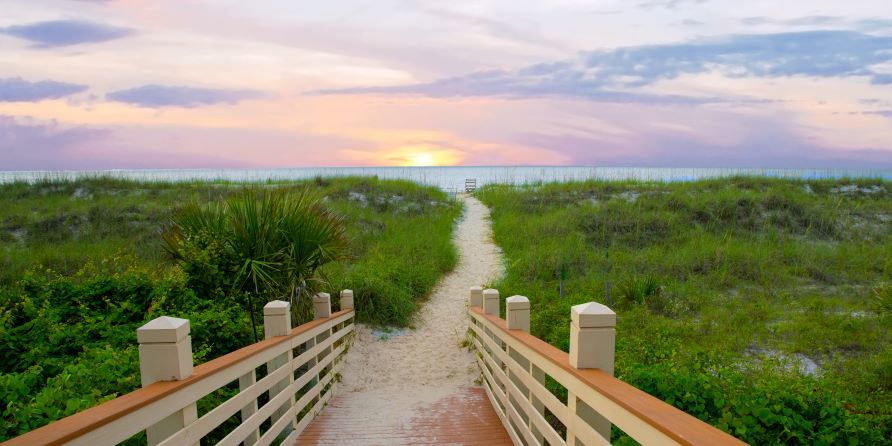Stunning sunset beach image, wooden walkway leading to beach, white sands, sunset painted skies overhead, Hilton Head, South Carolina.