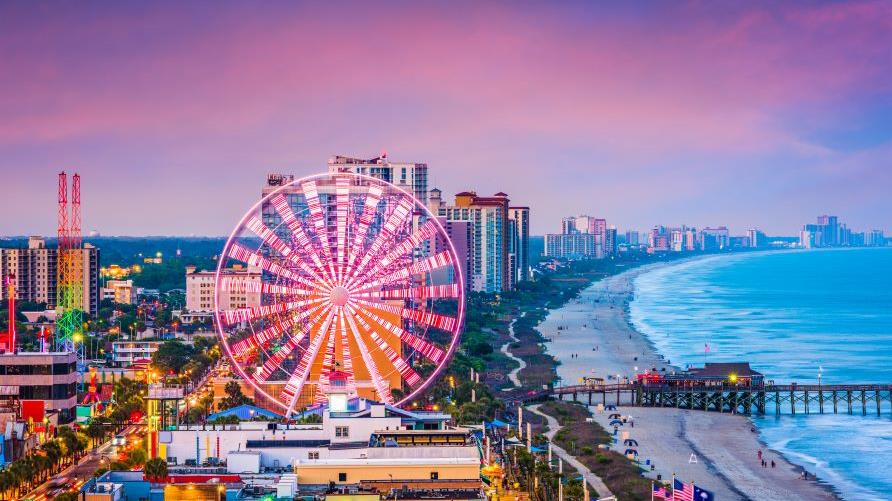 Stunning aerial image, Grand Strand, boardwalk, SkyWheel glowing brightly against night sky, Myrtle Beach, South Carolina. 