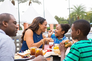 Family enjoying a lunch of burgers and fries together.