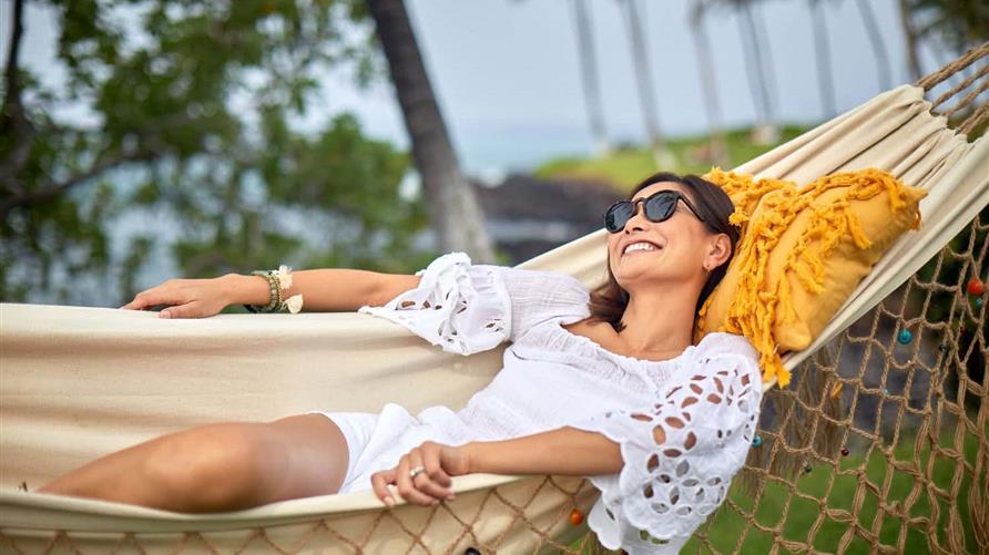 Woman smiling while  lounging in a hammock. 