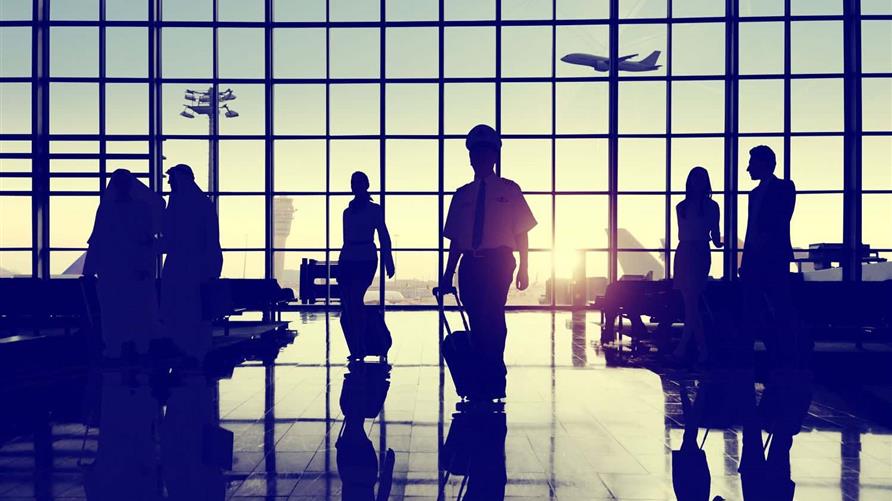 Air-passengers watching the planes through the airport window at the terminal. 