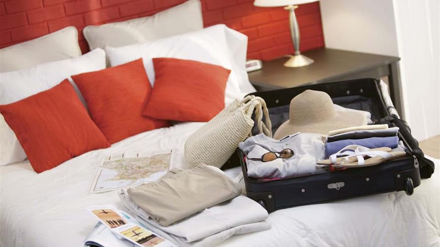 A suitcase laid open on a bed. 