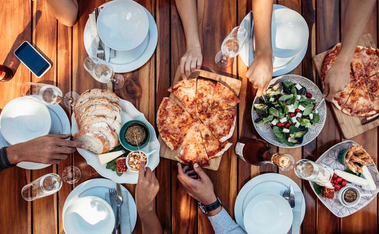 Overhead shot of people enjoying a family style meal. 