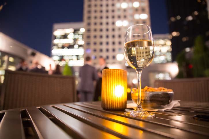 Wine glass on a table with New York City Skyline in the background. 