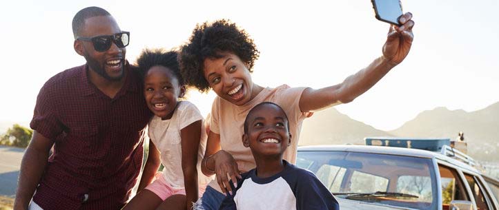 Family taking a selfie picture on a road trip.