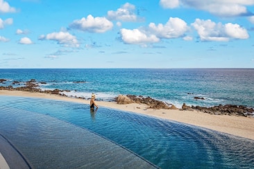 Long swimming pool that abuts with the beach by the sea