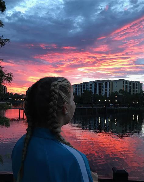 Young girl looking at colorful sunset