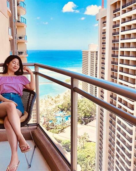 Women sitting on a balcony overlooking Waikiki Beach.